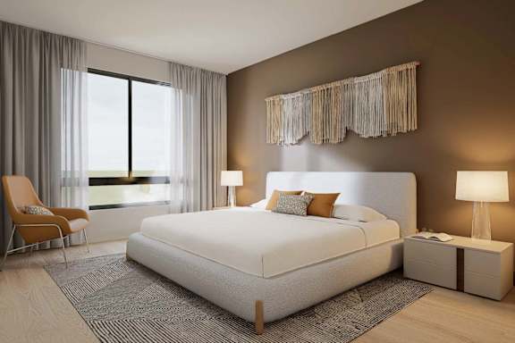 A bedroom with a large bed, a chair, and a window with curtains.