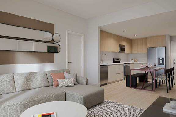 A modern living room with a grey couch and a dining table set up.