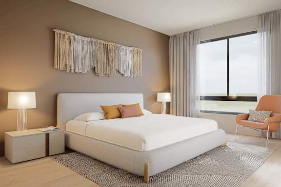 A bedroom with a large bed, a chair, and two lamps.