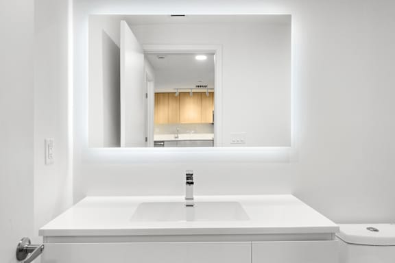 A white sink in a bathroom with a mirror above it.