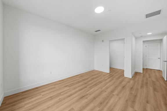 A room with wooden flooring and white walls.