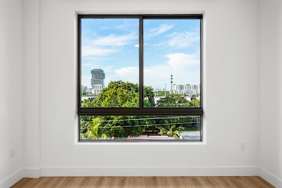 A large window with a view of a city skyline and greenery outside.