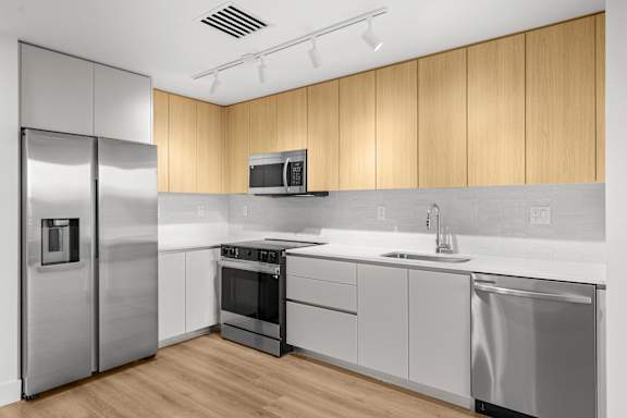 A modern kitchen with wooden cabinets and stainless steel appliances.