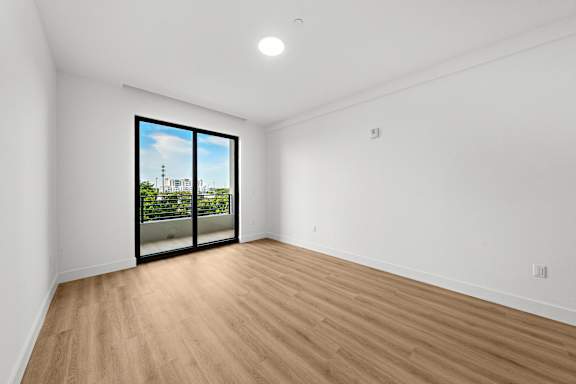 A room with a large window and wooden flooring.