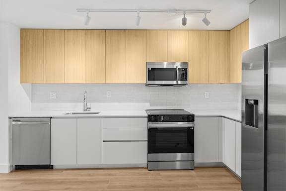 A modern kitchen with wooden cabinets and stainless steel appliances.