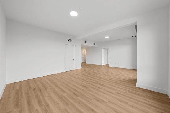 A room with wooden flooring and white walls.