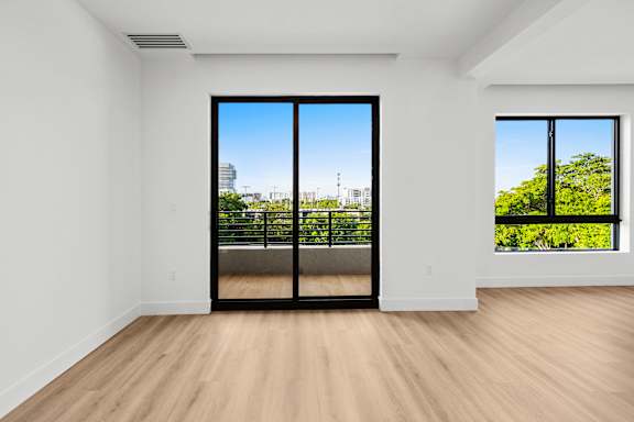 A room with a view of the city through a large window.