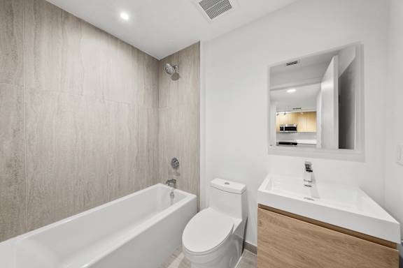 A white bathroom with a tub, toilet and sink.