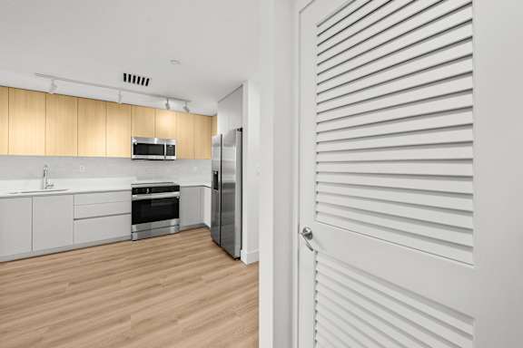 A kitchen with white cabinets and a refrigerator.