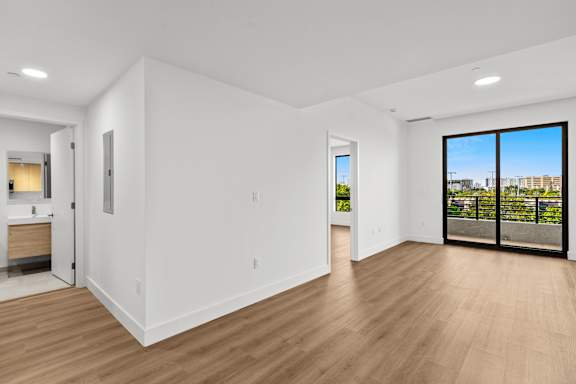 A large empty room with wooden floors and white walls.