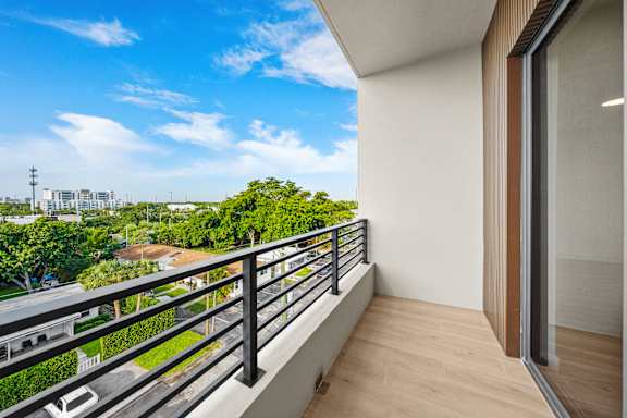 A balcony with a view of a street and buildings.