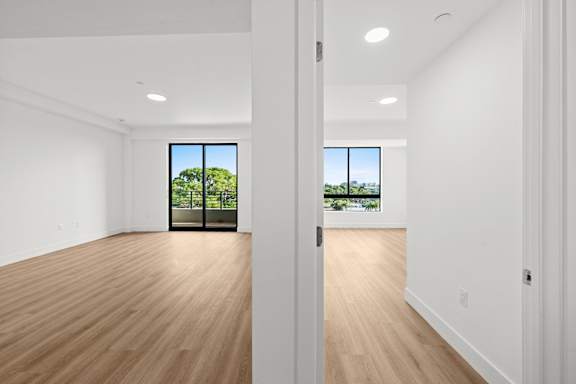 A room with wooden floors and a large window.