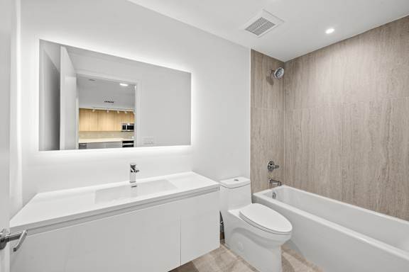 A modern bathroom with a white sink and toilet.