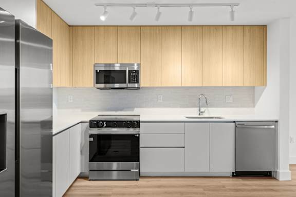 A modern kitchen with wooden cabinets and stainless steel appliances.