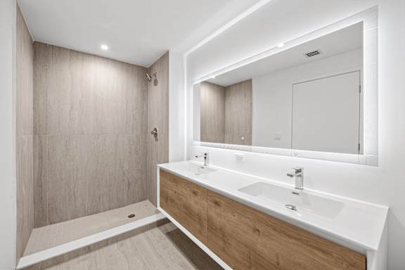 A modern bathroom with a white sink and a mirror above it.