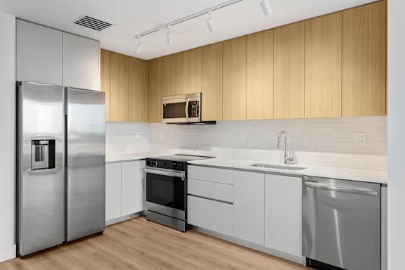 A modern kitchen with wooden cabinets and stainless steel appliances.