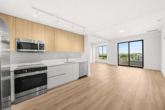 A modern kitchen with wooden cabinets and stainless steel appliances.