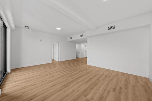 A room with wooden flooring and white walls.