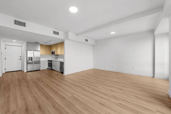 A kitchen with wooden floors and white walls.