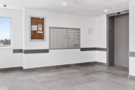 A white hallway with a calendar and a door.