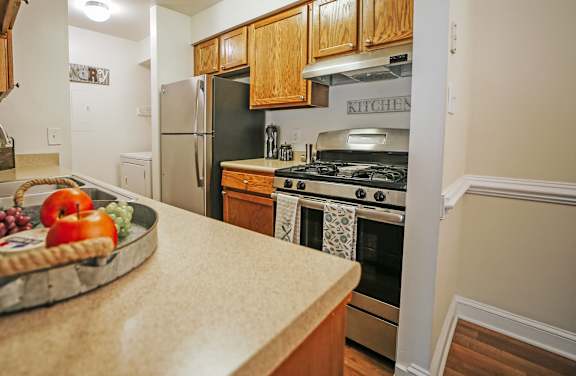 A kitchen with a black refrigerator and a wooden counter.