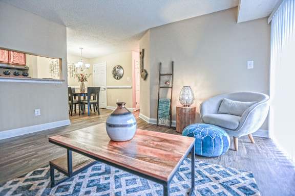 A living room with a wooden coffee table and a blue patterned rug.
