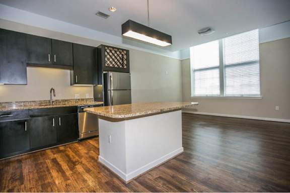 A kitchen with black cabinets and a granite countertop.