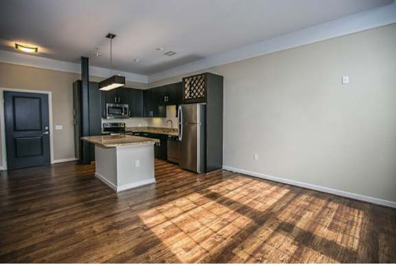 A kitchen with a wooden floor and a white island.