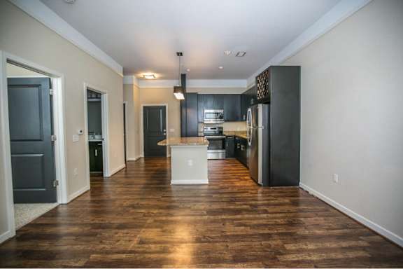 A kitchen with dark wood floors and white appliances.