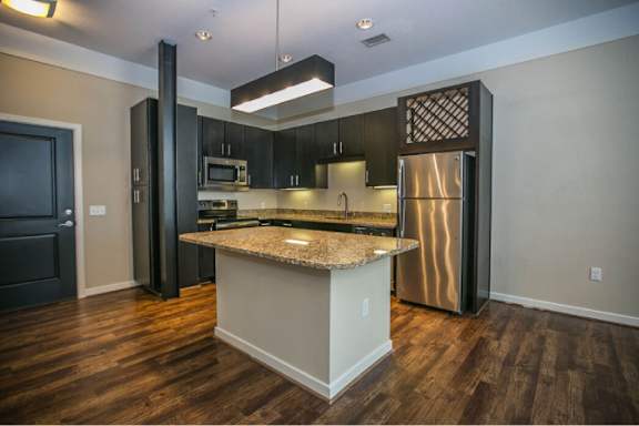 A kitchen with a granite countertop and stainless steel appliances.