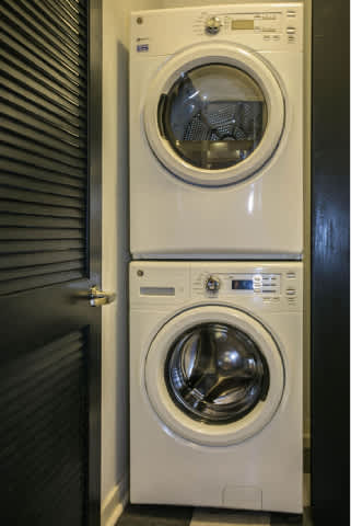 Two white front loading washing machines in a laundry room.