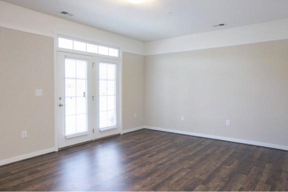 A room with a wooden floor and a white door.