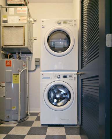 A white washing machine sits in a laundry room.