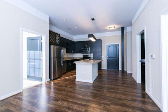 A kitchen with a refrigerator, microwave, and oven.