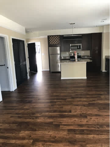 A kitchen with a refrigerator, microwave, and oven.