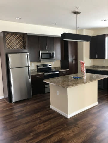 A kitchen with a granite countertop and a refrigerator.