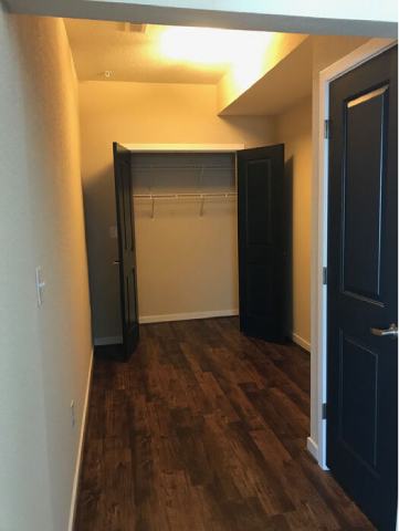 A hallway with a black door and a white door.