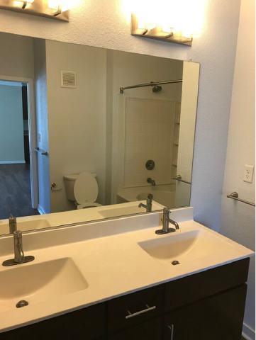 A bathroom with a white sink and a mirror.