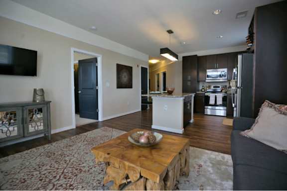 A modern living room with a wooden coffee table in the center.
