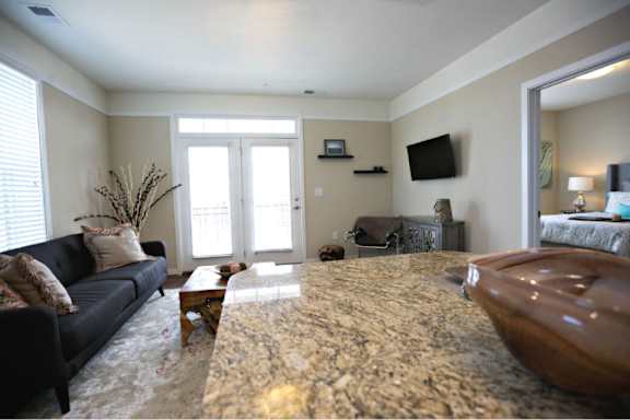 A living room with a black couch and a marble countertop.