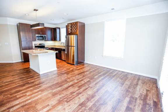 A kitchen with wooden floors and white walls.