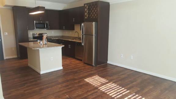 A kitchen with a refrigerator, microwave, and countertop.