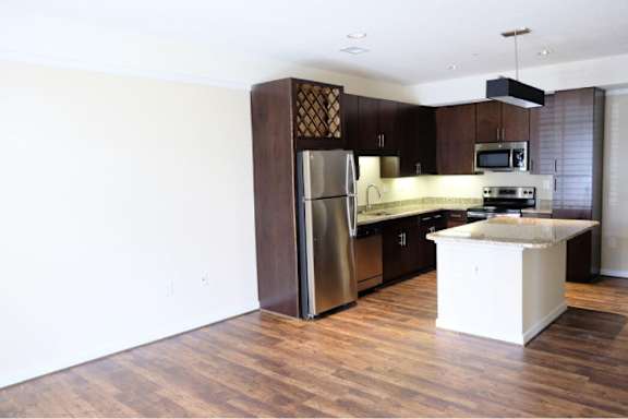 A kitchen with a refrigerator, microwave, and oven.