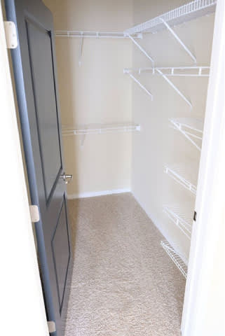 A white refrigerator with a black door is in a room with a carpeted floor.