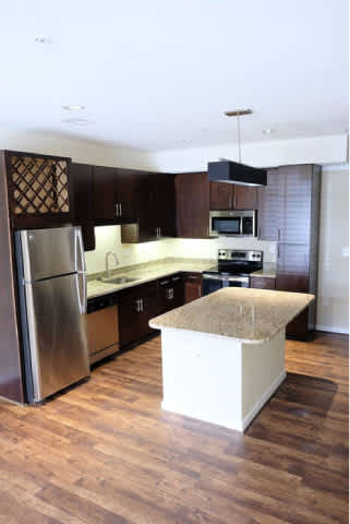 A kitchen with a refrigerator, microwave, and oven.