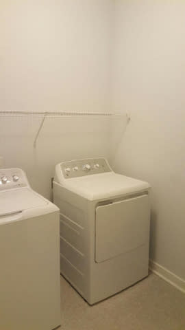A white washing machine and dryer in a small laundry room.