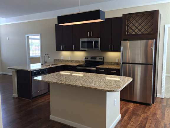 A kitchen with a granite countertop and stainless steel appliances.
