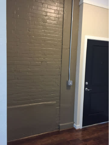 A black door is on the right side of a white wall.