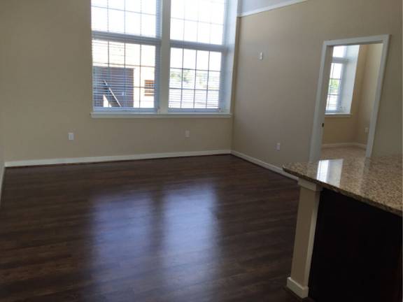 A room with wooden floors and a large window.