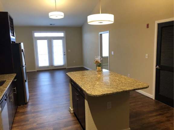 A kitchen with a granite countertop and a refrigerator.